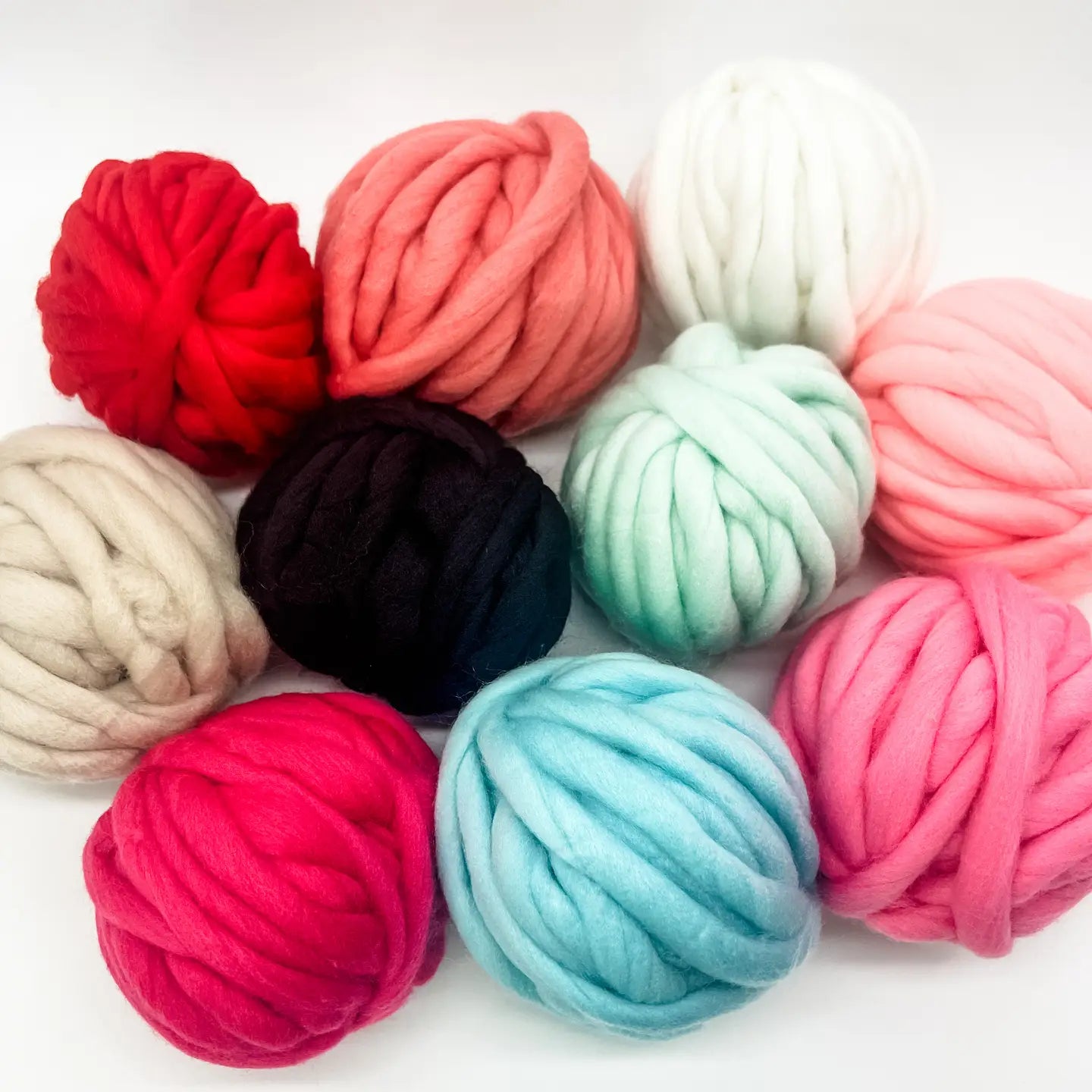 Assorted colorful balls of yarn on a white background