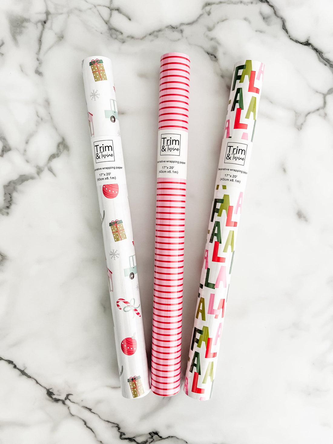 Three rolls of decorative paper with festive designs 