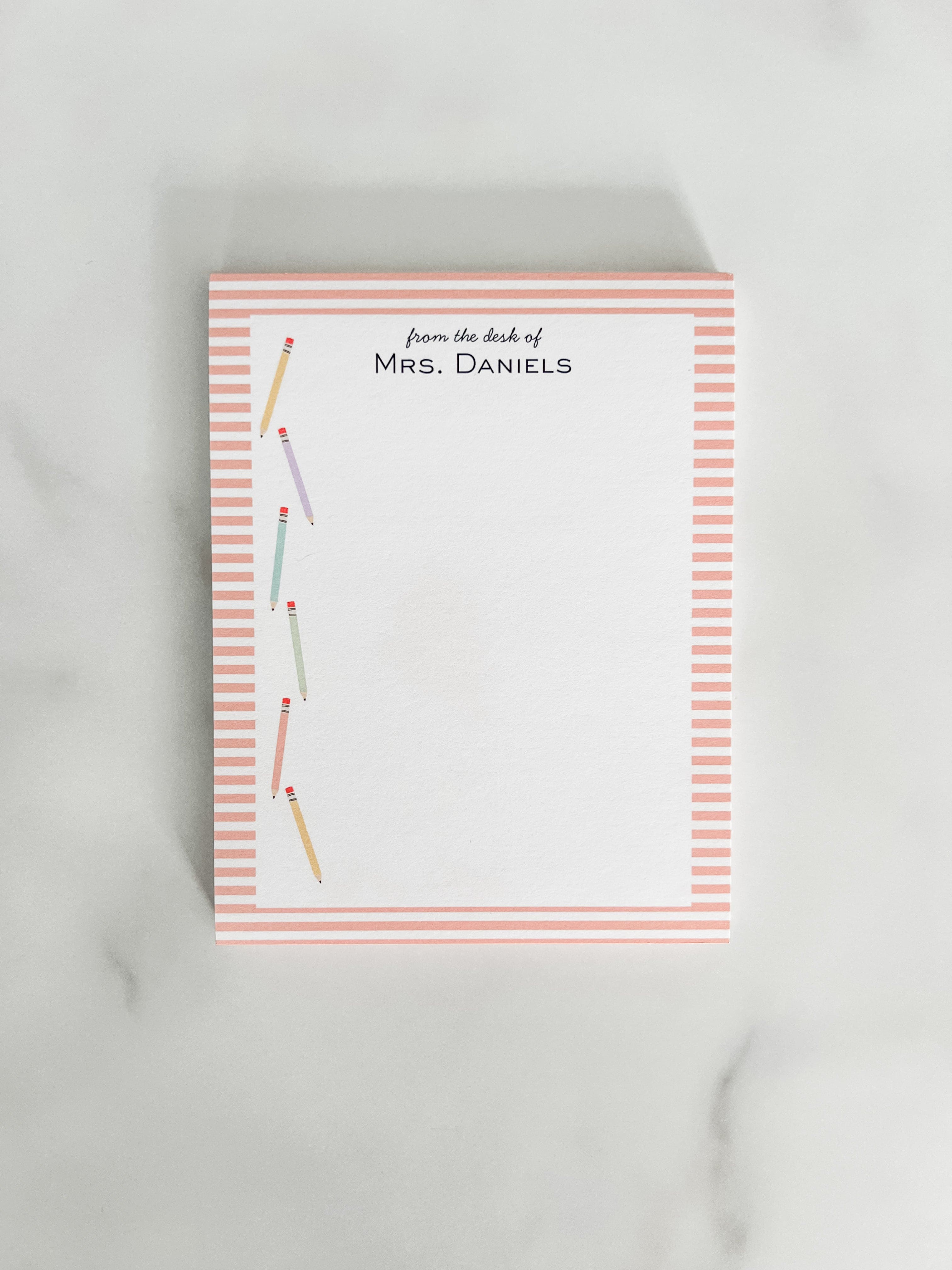 Personalized teacher notepad with colorful pencils and a striped edge.