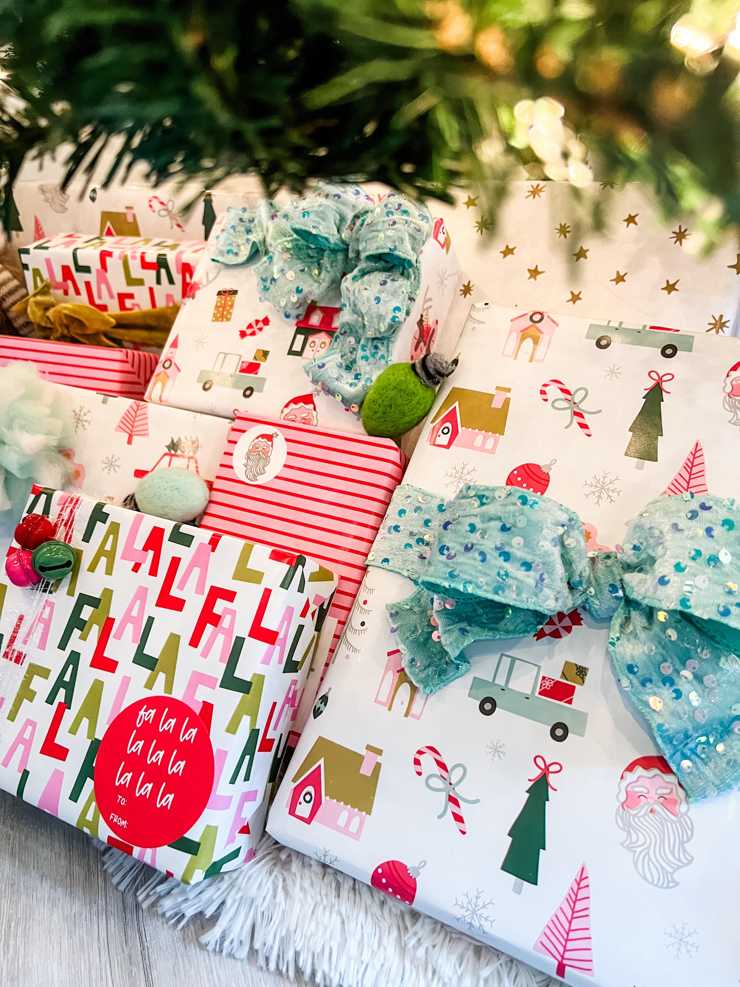 Christmas-themed gift wrap with festive designs under a decorated tree.