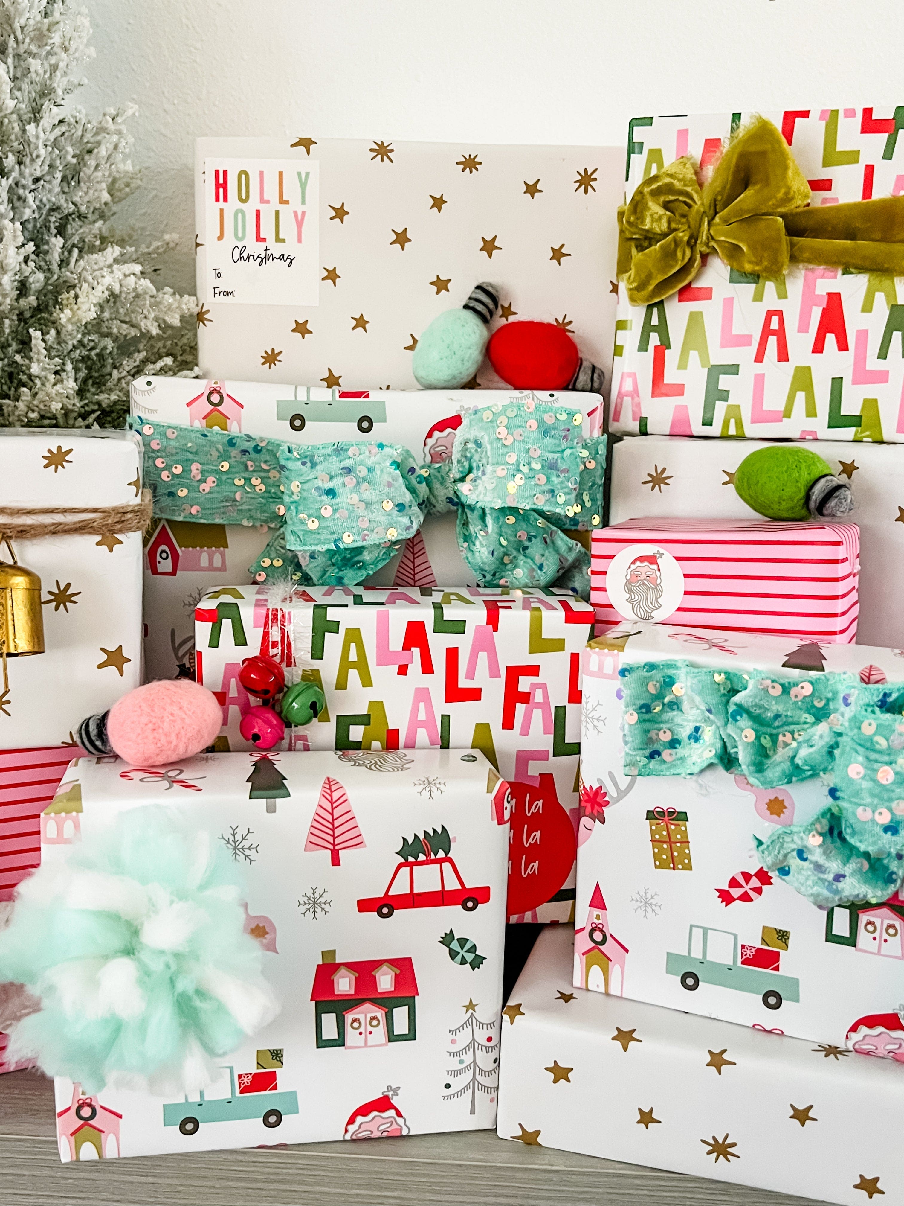 Stack of Christmas presents wrapped in festive paper with decorative ribbons and bows.